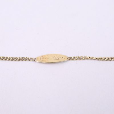 un bracelet en chaîne d'or sur lequel est gravé un petit ovale
