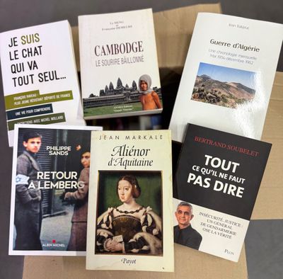 several books are sitting in a cardboard box on a table