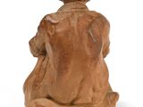 statue of a man sitting on a rock with a hat on