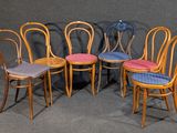 quatre chaises en bois sont alignées sur un fond gris
