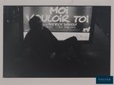 photo en noir et blanc d'un homme assis devant un téléviseur