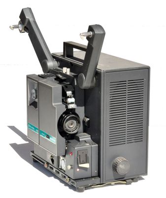 un vieux projecteur de cinéma posé sur une palette