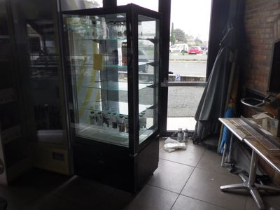 une vitrine en verre dans le coin d'une pièce