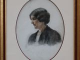 On y voit un tableau représentant un homme en veste noire, présenté dans un cadre doré.