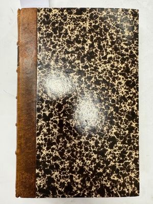 un gros plan d'un livre posé sur une table, avec un bout de papier à côté