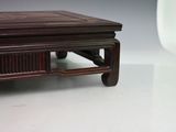 a small table with a wooden top on a white surface