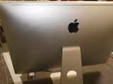 a silver apple computer sitting on a stand in a room