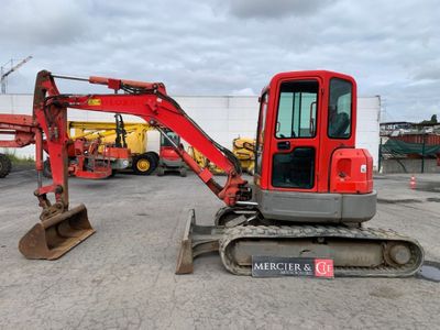 l'arrière d'une pelleteuse rouge garée sur un parking