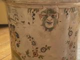 an old tin can sitting on the floor in front of a window