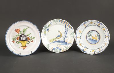 trois assiettes ornées d'oiseaux et de fleurs, posées sur une table