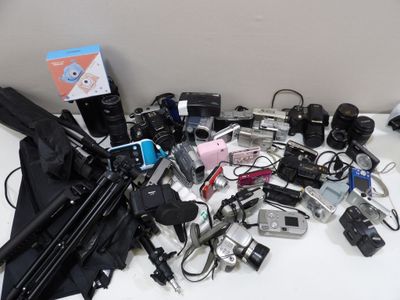 a lot of cameras and other electronics on the table