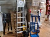une pile de cartons et un diable dans un entrepôt