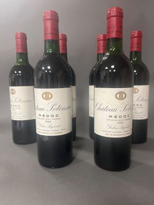 quatre bouteilles de vin rouge sont alignées sur une table