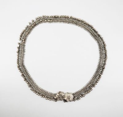 a close up of a silver necklace on a white background
