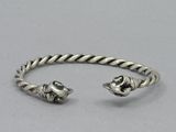 a close up of a silver bracelet with two skulls on it