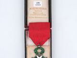 an old medal with a red ribbon and a star on it