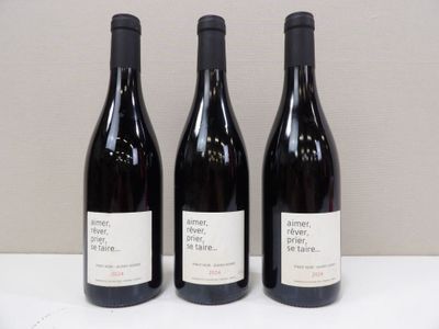 trois bouteilles de vin sont alignées sur une table