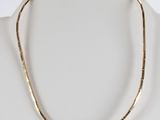 a gold and silver necklace on a mannequin mannequin mannequin mannequin mannequin mannequin mannequin mannequin mann