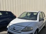 une petite voiture blanche garée à côté d'une voiture bleue