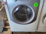 une machine à laver posée sur une palette dans un magasin
