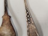 two spoons that are sitting next to each other on a table