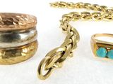 plusieurs bagues et bracelets de styles variés posés sur une surface blanche
