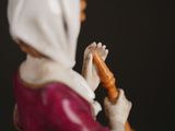 a figurine of a woman holding a carrot in her hand