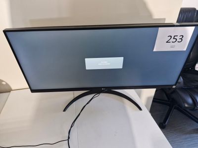 un écran d'ordinateur posé sur un bureau, avec une étiquette de prix dessus