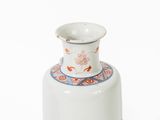 a white vase with a red and blue design on it
