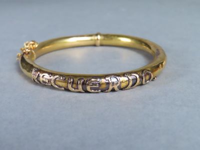 a close up of a gold bangle with small beads on it