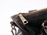 a black purse with a gold zipper on it
