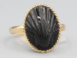 a close up of a gold ring with a black stone in it