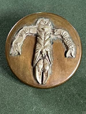 un badge métallique sur lequel figure l'image d'un homme
