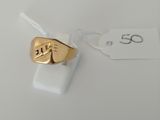 a close up of a gold ring on a white surface with a price tag