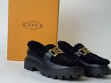 the black loafer is next to a box and a pair of shoes