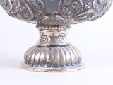 a silver vase with a flower design on it