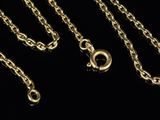 a close up of three gold chains on a black background