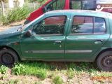 a small green car that is parked in the grass