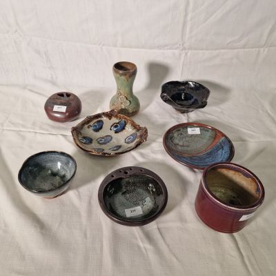 many different types of pottery sitting on a table