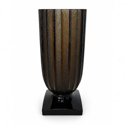 un vase en verre posé sur un socle noir