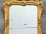 un miroir accroché au mur, avec un cadre doré