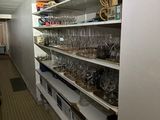 many empty wine glasses on the shelves in the kitchen