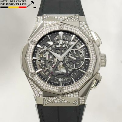 La montre est en acier inoxydable et est dotée d'un bracelet en cuir noir.