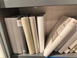 a book shelf with many books on it and a pair of scissors on the shelf