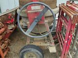 a picture of a wheel and some pipes in a yard