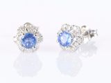 paire de boucles d'oreilles à clous en saphir bleu et diamants sur fond blanc