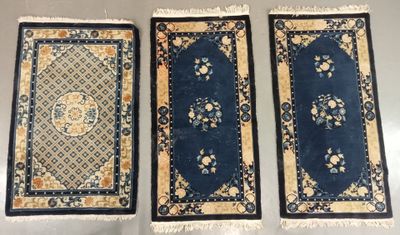 three oriental rugs are lined up on a table