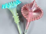 pair of pink and blue flower shaped glass vases on a gray surface