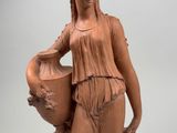 statue of a woman holding a vase and a vase on a pedestal
