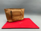 un sac fourre-tout en cuir beige posé sur une serviette rouge